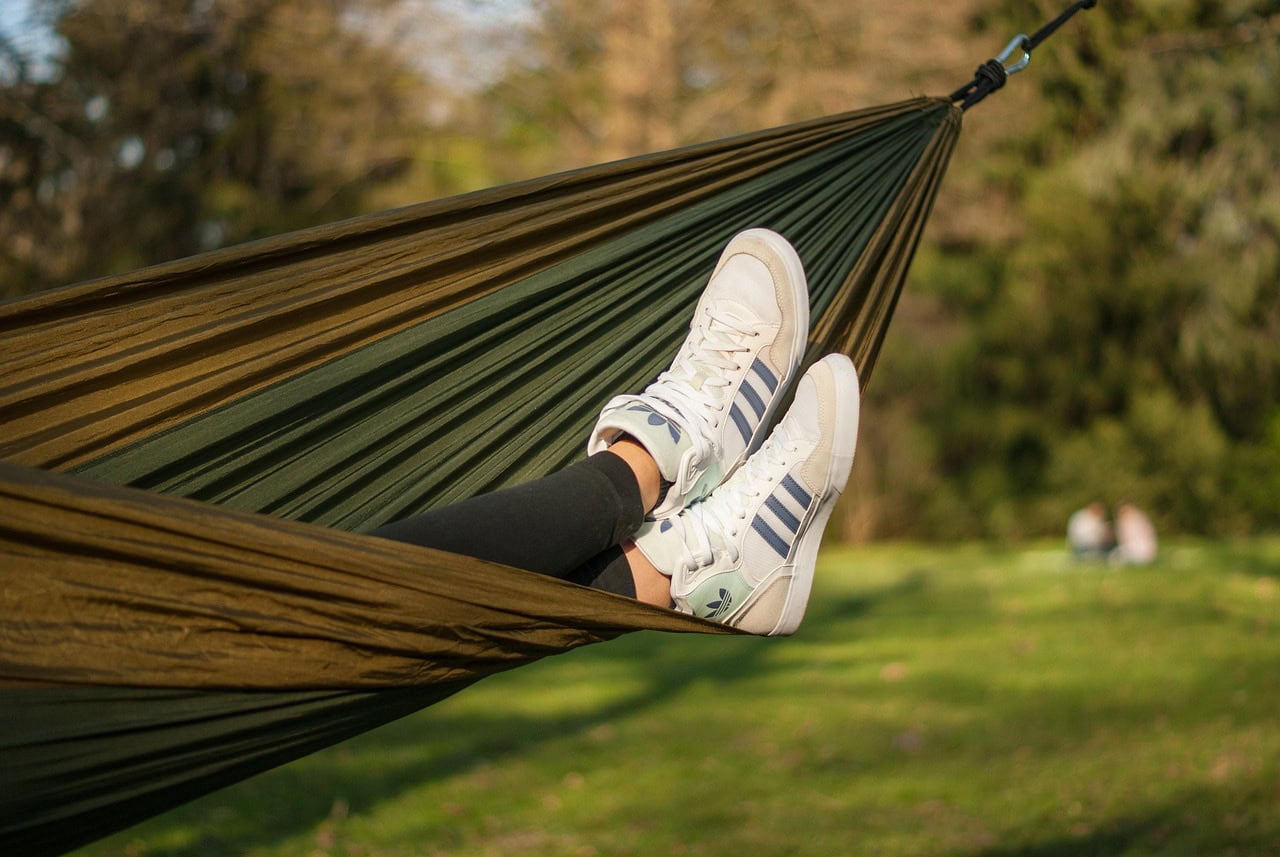 Person mit Sneaker auf Hängematte