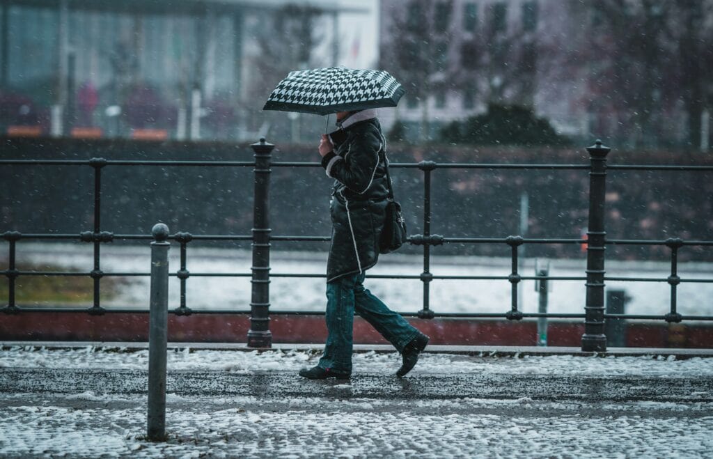 Person Regenschirm an Straße