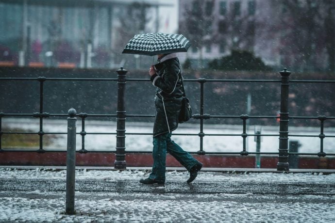 Person Regenschirm an Straße